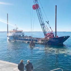Plovilo z žerjavom kopalcem pred barkovljansko obalo (DEŽELA FJK)