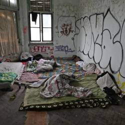 Nepalski begunec, ki ga je obšla slabost, živi v opuščenih skladiščih Starega pristanišča