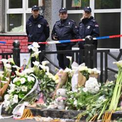 Policisti in cvetje pred šolo, kjer je 13-letnik ubijal (ANSA)