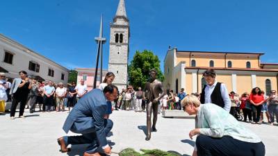 Predsednica RS Nataša Pirc Musar in sežanski župan Andrej Sila ob odkritju kipa Srečka Kosovela junija lani, v ozadju cerkev (FOTODAMJ@N)