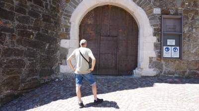 Turist zaman čaka pred vhodnimi vrati goriškega gradu (BUMBACA)