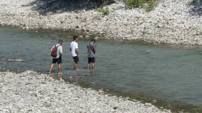 Tudi migranti v teh vročih dneh iščejo ohladitev v reki (BUMBACA)