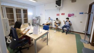Nekaj študentov je po prejetju odmerka cepiva sedelo v čakalnici