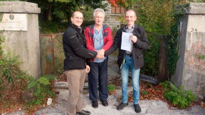 Uradna predaja ključa pred vhodom v nekdanjo osnovno šolo