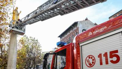 Gasilci so na pozlačen Marijin kip z avtolestvijo obesili venec belega cvetja