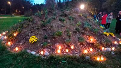 Cvetje in sveče na zemlji iz Buče v parku v Vilniusu