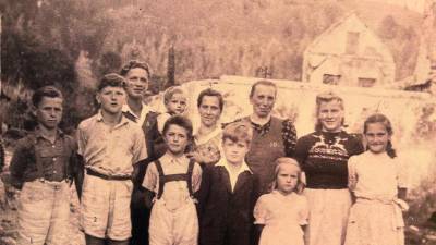 Preživeli družin Sadovnik in Kogoj leta 1946 pred uničeno domačijo v Koprivni pod Peco