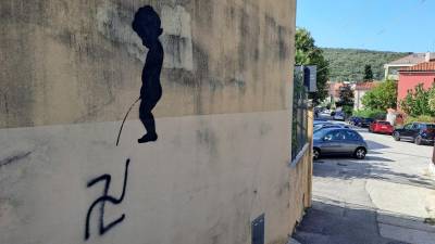 Deček lula na svastiko, ki se je pojavila na zidu ob svetoivanskem Marijinem domu