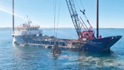 Plovilo z žerjavom kopalcem pred barkovljansko obalo (DEŽELA FJK)