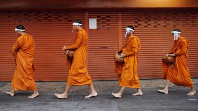 Budistični menihi z obraznimi ščitniki v Bangkoku (ANSA)