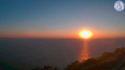 Obdobje s sončnim vremenom se bo jutri zaključilo. Pogled na Tržaški zaliv ob današnjem sončnem zatonu (SPLETNA KAMERA CISAR)