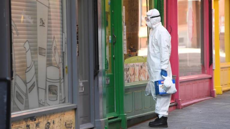 Oseba v zaščitni obleki na ulici v Londonu (ANSA)