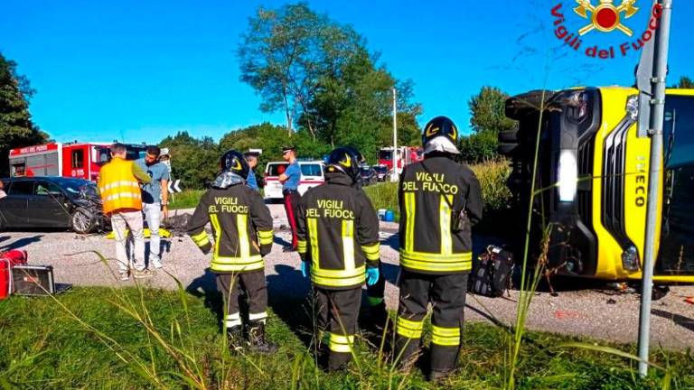 Šolski avtobus, poln otrok, po trčenju pristal na boku