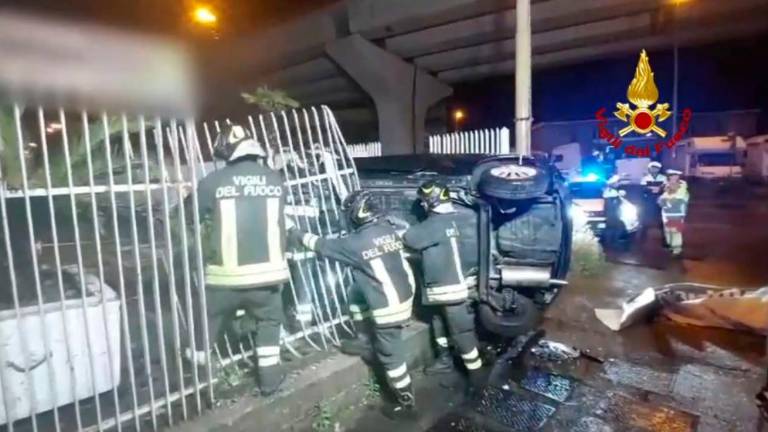 Avtomobil zapeljal s ceste in se na boku zagozdil ob ograjo